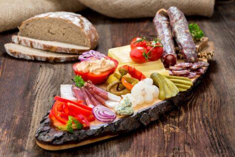 Brotzeitbrett mit Wurst, Käse und eingelegtem Gemüse
