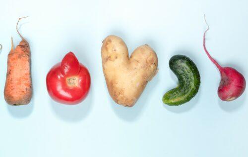 Gem&uuml;se in einer Reihe mit spezieller Form, wie die Herzkartoffel oder die Tomate mit Horn, auf einem himmelblauen Hintergrund.